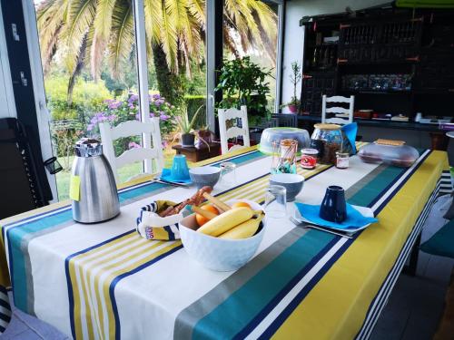 une table avec un bol de fruits sur un tissu de table rayé dans l'établissement maison et table d'hôtes Xori Kanta, à Ascain