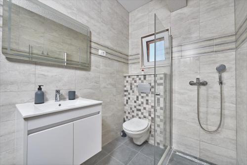a bathroom with a shower and a toilet and a sink at Apartments & Rooms Seaside in Kaštela