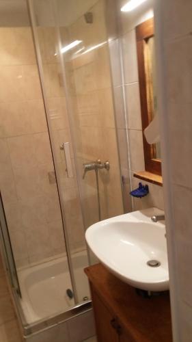 La salle de bains est pourvue d'une douche et d'un lavabo blanc. dans l'établissement GITE PAPY ALBERT, à Gruissan