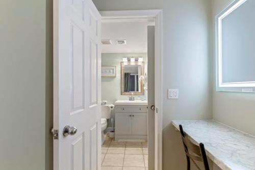 Un baño con lavabo, inodoro y espejo. en Scenic Views from the balcony at Ocean Forest Plaza Condos, en Myrtle Beach