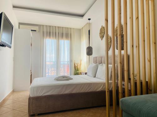a bedroom with a large bed and a television at Summer Dreams Studios in Skala Potamias