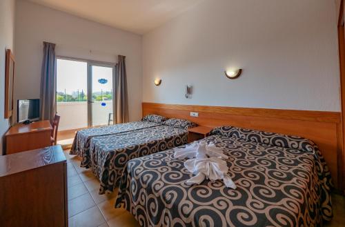 a hotel room with two beds and a television at Santa Susanna Resort in Santa Susanna