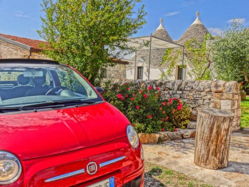 a red car parked in front of a house at Masseria Rosa Trulli Relais in Alberobello