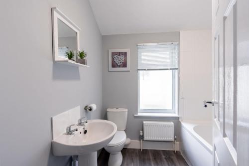 Baño blanco con lavabo y aseo en Modern & Beach Location & Contractors & Leisure & Garden, en Grimsby