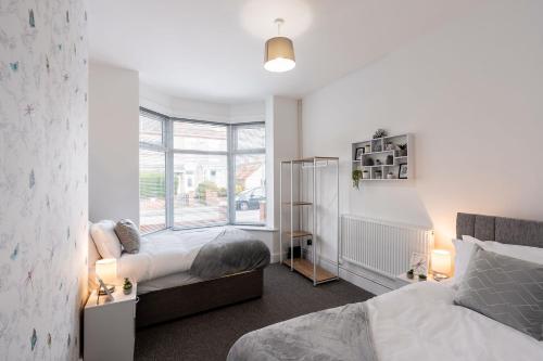 1 dormitorio con 2 camas y ventana en Modern & Beach Location & Contractors & Leisure & Garden, en Grimsby