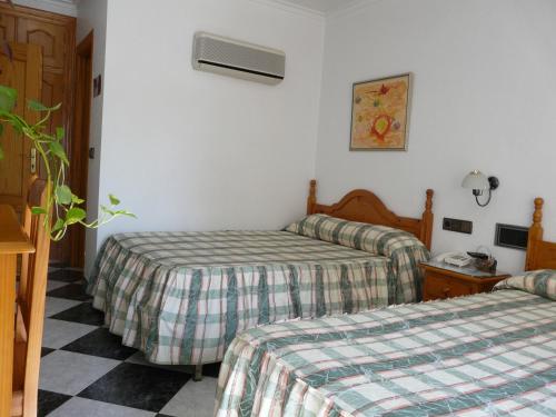 a hotel room with two beds in a room at Hotel Guillermo II in Mazarrón