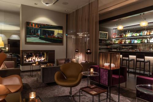 a bar with chairs and a fireplace in a room at Hotel 47° in Konstanz