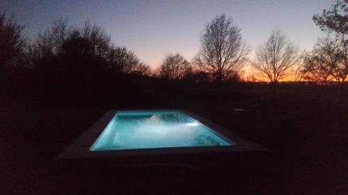 a swimming pool in the middle of a field at sunset at SafariLodge 6 persoons in Chaumont