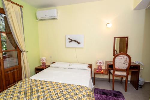 a bedroom with a bed and a desk and a chair at Aeolos Guesthouse in Monemvasia