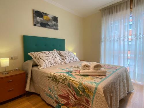 a bedroom with a bed with towels on it at APARTAMENTO FUNCIONAL LALIN-CENTRO in Lalín