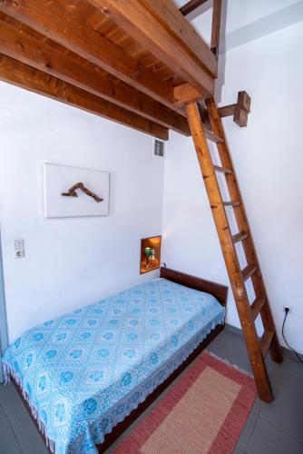 a bedroom with a bed with a wooden ladder at Aeolos Guesthouse in Monemvasia