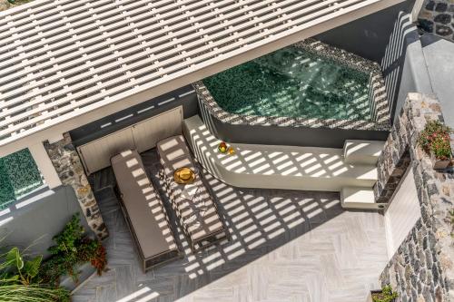 an overhead view of a patio with chairs and a swimming pool at Wine and Yard Caves in Pyrgos