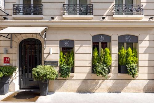 un bâtiment avec un portail et des plantes aux fenêtres dans l'établissement Hotel Residence Foch, à Paris