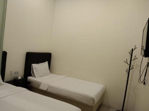 سرير أو أسرّة في غرفة في GRAND TOBA HOTEL