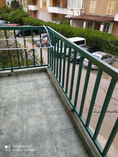 um corrimão verde ao lado de um passeio com estacionamento em Apartman Podkošljun em Budva