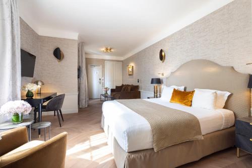 a hotel room with a large bed and a desk at Hotel Residence Foch in Paris