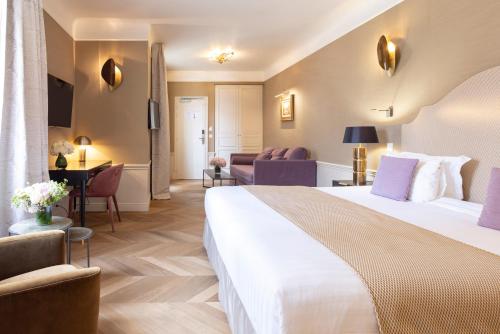 a hotel room with a large bed and a living room at Hotel Residence Foch in Paris