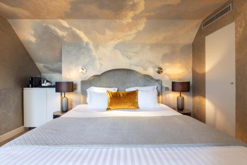 a bedroom with a large bed with two lamps at Hotel Residence Foch in Paris