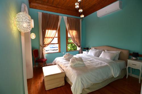 a bedroom with a large bed with blue walls at Amina Hanem Boutique Apartments in Kavala