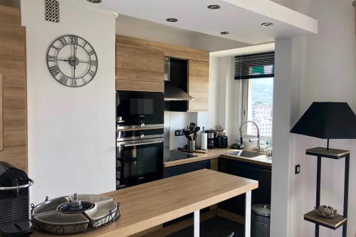 een keuken met een grote klok aan de muur bij Cosy 42m With Balcony Nice View And Wifi in Cannes