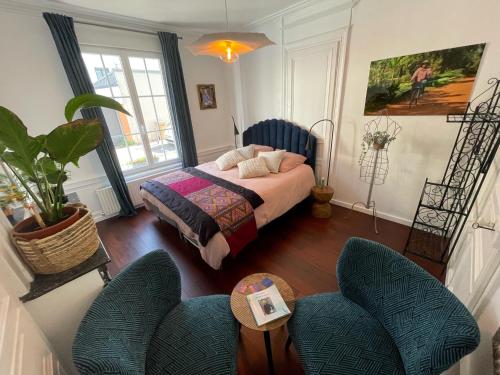 a bedroom with a bed and two chairs at 3DALIPHARD in Rouen