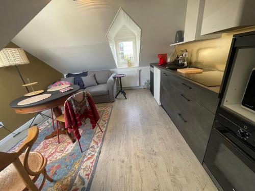a living room with a table and a kitchen at 3DALIPHARD in Rouen