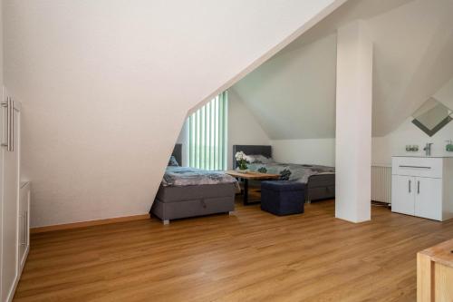 a attic bedroom with two beds and a table at Ferienwohnung Alpenblick in Friedrichshafen