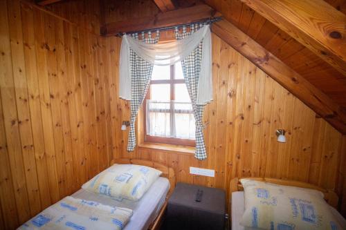 a bedroom with two beds in a wooden cabin at Radics Panzió Étterem és Pihenő Központ in Letenye