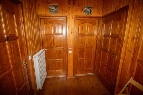a hallway with wood paneling and two doors at Radics Panzió Étterem és Pihenő Központ in Letenye