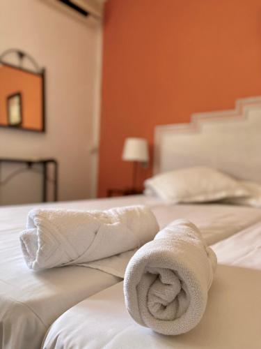 two white towels sitting on top of a bed at Hostal Los Arcos in Vejer de la Frontera