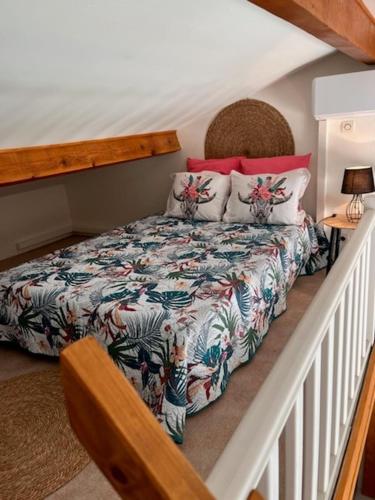 une chambre avec un lit avec un couvre-lit fleuri dans l'établissement Un petit coin sympa, à Draguignan