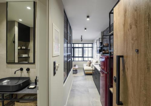 een badkamer met een wastafel en een spiegel in een kamer bij Olvios Lofts @Ladadika in Thessaloniki