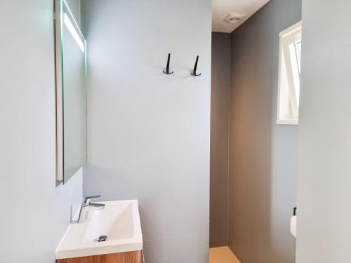 a bathroom with a sink and a mirror at Nieuw! OK40 Landelijk gelegen Chalet in Oostkapelle