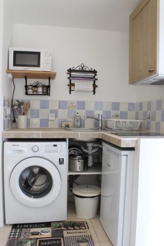 a kitchen with a washing machine and a microwave at Gite La clef du Sud in Salernes