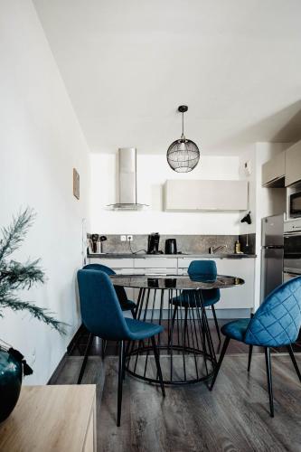 une cuisine avec des chaises bleues et une table à manger dans l'établissement T2 Haut Standing Parking privé Wi-Fi TV Netflix, à Valenciennes