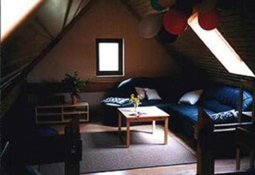 Ferienhaus Kamp Familie Diebenow في Kamp: غرفة معيشة مع أريكة زرقاء وطاولة