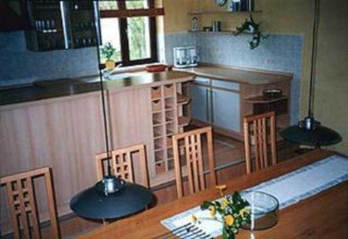 une cuisine avec une table en bois, des chaises et un comptoir dans l'établissement Ferienhaus Kamp Familie Diebenow, à Kamp