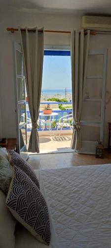 a bedroom with a bed with a view of the ocean at Villa Dioni in Kamari