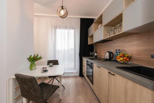 a kitchen with a table and a white counter top at Apartamenty Centrum II in Bydgoszcz