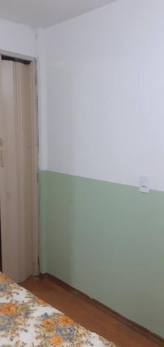 a bedroom with a bed and a white wall at ALVORADA PLACE in Santo André