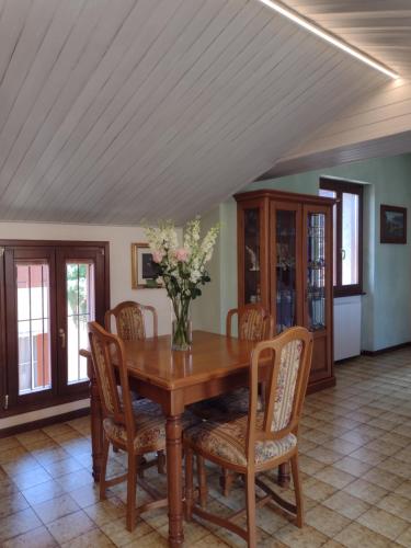 a dining room table with chairs and a vase of flowers at Casa Gabri in Toscolano Maderno