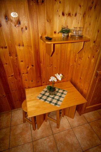 a wooden room with a table with flowers on it at Radics Panzió Étterem és Pihenő Központ in Letenye