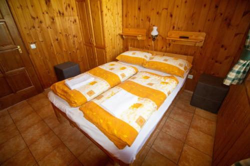 a bedroom with two beds with yellow and white sheets at Radics Panzió Étterem és Pihenő Központ in Letenye