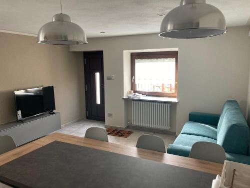uma sala de estar com um sofá azul e uma televisão em Senin House em Aosta