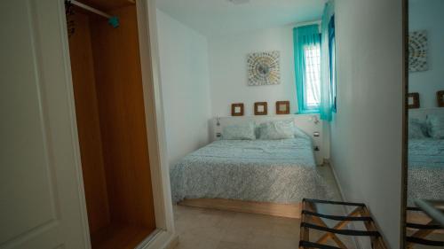 sypialnia z łóżkiem i oknem w obiekcie Apartamento Los Patos Beach w mieście Benalmádena