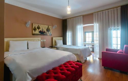 a hotel room with two beds and a red couch at Zendy Suite Hotel in Istanbul