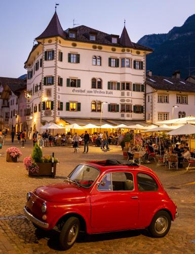 an old red car parked in front of a building at Weisses Rössl in Caldaro