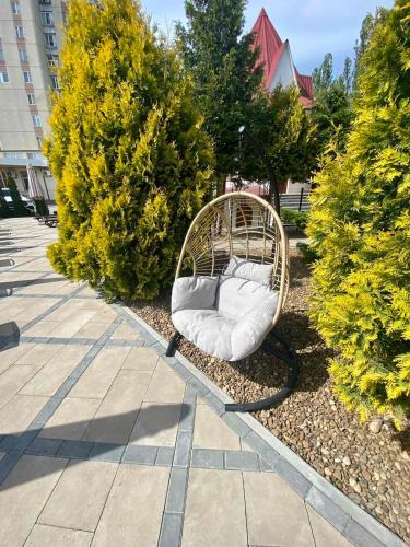a rattan bed sitting in the middle of a garden at In hotel in Kamianets-Podilskyi