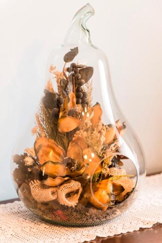 a glass vase filled with dried flowers on a table at La Casa dei Nonni B&B in Scanno