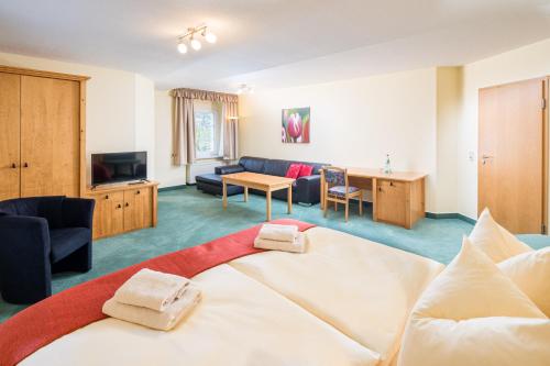 a hotel room with a bed and a living room at Landhaus Purschenstein in Neuhausen